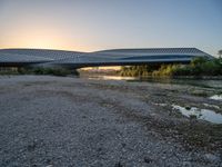 there are two very long bridges that are above the river shore at dusk here, and you can see how close them are