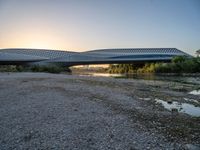 there are two very long bridges that are above the river shore at dusk here, and you can see how close them are