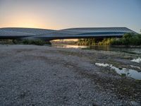 there are two very long bridges that are above the river shore at dusk here, and you can see how close them are