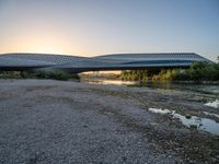 there are two very long bridges that are above the river shore at dusk here, and you can see how close them are