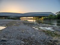 there are two very long bridges that are above the river shore at dusk here, and you can see how close them are