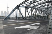 a long bridge crossing over the river in shanghai, china, and the big city beyond