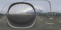 two fisheye images of a bridge with a cloudy sky in the background and traffic lights