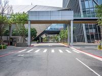 there is a bridge over the street near buildings and trees near it and some traffic signs