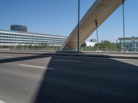 a truck driving across a bridge near a street corner near buildings and a bridge with many cables