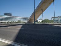 a truck driving across a bridge near a street corner near buildings and a bridge with many cables