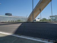 a truck driving across a bridge near a street corner near buildings and a bridge with many cables