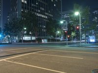 there is a bright blue light at an intersection, in a city street at night