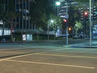 there is a bright blue light at an intersection, in a city street at night