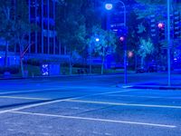 there is a bright blue light at an intersection, in a city street at night