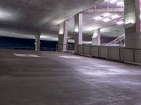 a building is lit up by bright led lights and railings over an empty parking space