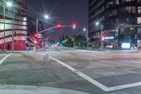 a night view of the intersection at a busy intersection, looking at some buildings and red lights