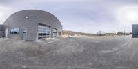 an empty street in front of an industrial building and a blue sky behind it,