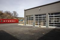 the outside of a building with some containers in it and a red container with white letters on it