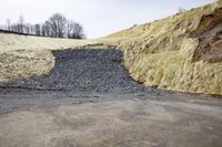 a pile of rocks is laying out on the side of the road near the cliff