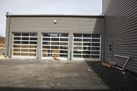 a garage door with a closed wooden sign on the side and a building with several doors