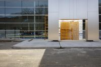 a door in a wall with construction equipment outside it's doorway and glass building