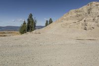 there is a bike rider on a paved dirt road through rocky area near a mountain