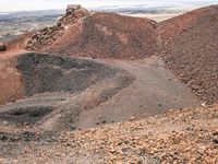 the area where there is red rocks and gravel on the ground and the road is marked with a black dot