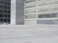 a skateboarder is riding through the parking garage of an empty building with columns