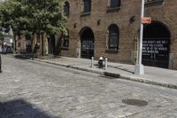 a street with brick and brick building next to a fire hydrant and a few trees