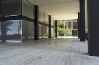 a black and white picture of a sidewalk in front of a building in the city