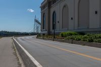 a side of a building on a highway and next to a yellow line of traffic