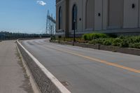 a side of a building on a highway and next to a yellow line of traffic