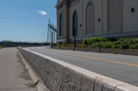 a side of a building on a highway and next to a yellow line of traffic