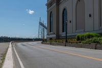 a side of a building on a highway and next to a yellow line of traffic