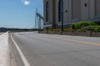 a side of a building on a highway and next to a yellow line of traffic