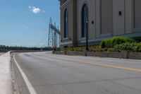 a side of a building on a highway and next to a yellow line of traffic