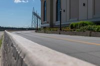 a side of a building on a highway and next to a yellow line of traffic