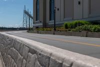 a side of a building on a highway and next to a yellow line of traffic