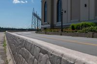 a side of a building on a highway and next to a yellow line of traffic