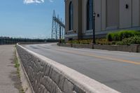 a side of a building on a highway and next to a yellow line of traffic