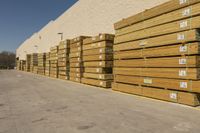 stacks of lumber are stacked up by the side of a building with white trims and tags on it