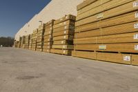 stacks of lumber are stacked up by the side of a building with white trims and tags on it