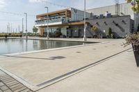 the woman is looking at the large building and pool area beside the building, with many plants