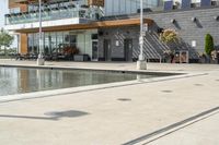 the woman is looking at the large building and pool area beside the building, with many plants