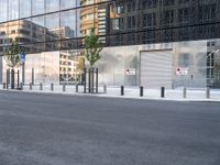 the reflection of a building on the side of a road shows a man on a skateboard