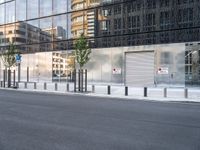 the reflection of a building on the side of a road shows a man on a skateboard