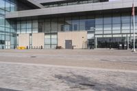 a building with tall glass walls on the outside and inside, in a plaza area