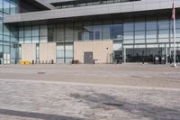 a building with tall glass walls on the outside and inside, in a plaza area