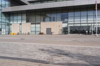 a building with tall glass walls on the outside and inside, in a plaza area