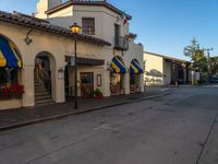 a large white building with yellow awnings and blue awnings on the side of a street