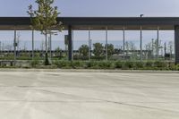 a bus stop with many windows in the background on a sunny day, it appears to be in a public transit area