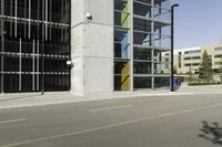 a young man rides down a busy road with a blue scooter in front of a large building