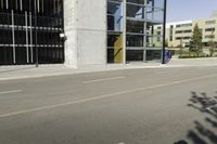 a young man rides down a busy road with a blue scooter in front of a large building