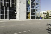 a young man rides down a busy road with a blue scooter in front of a large building